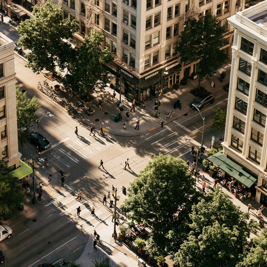 Aerial view of a busy city intersection with shoppers, a grocery and sidewalk cafes